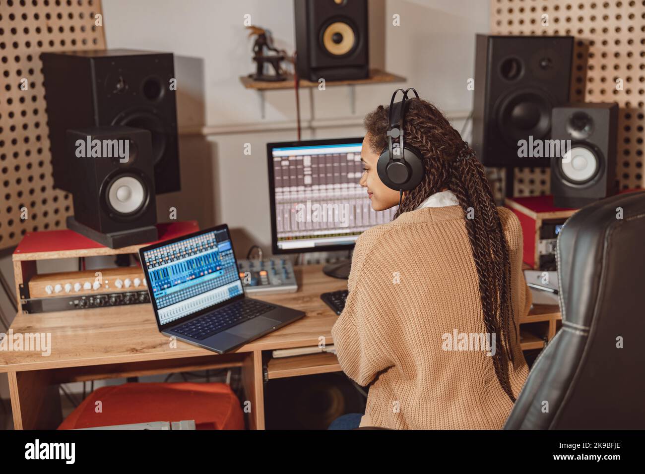 African American anchor woman sitting in front of microphone and laptop ...