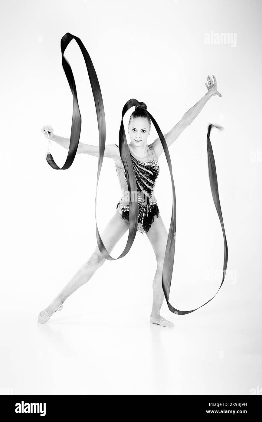 a girl from rhythmic gymnastics in a standing bodysuit shows an