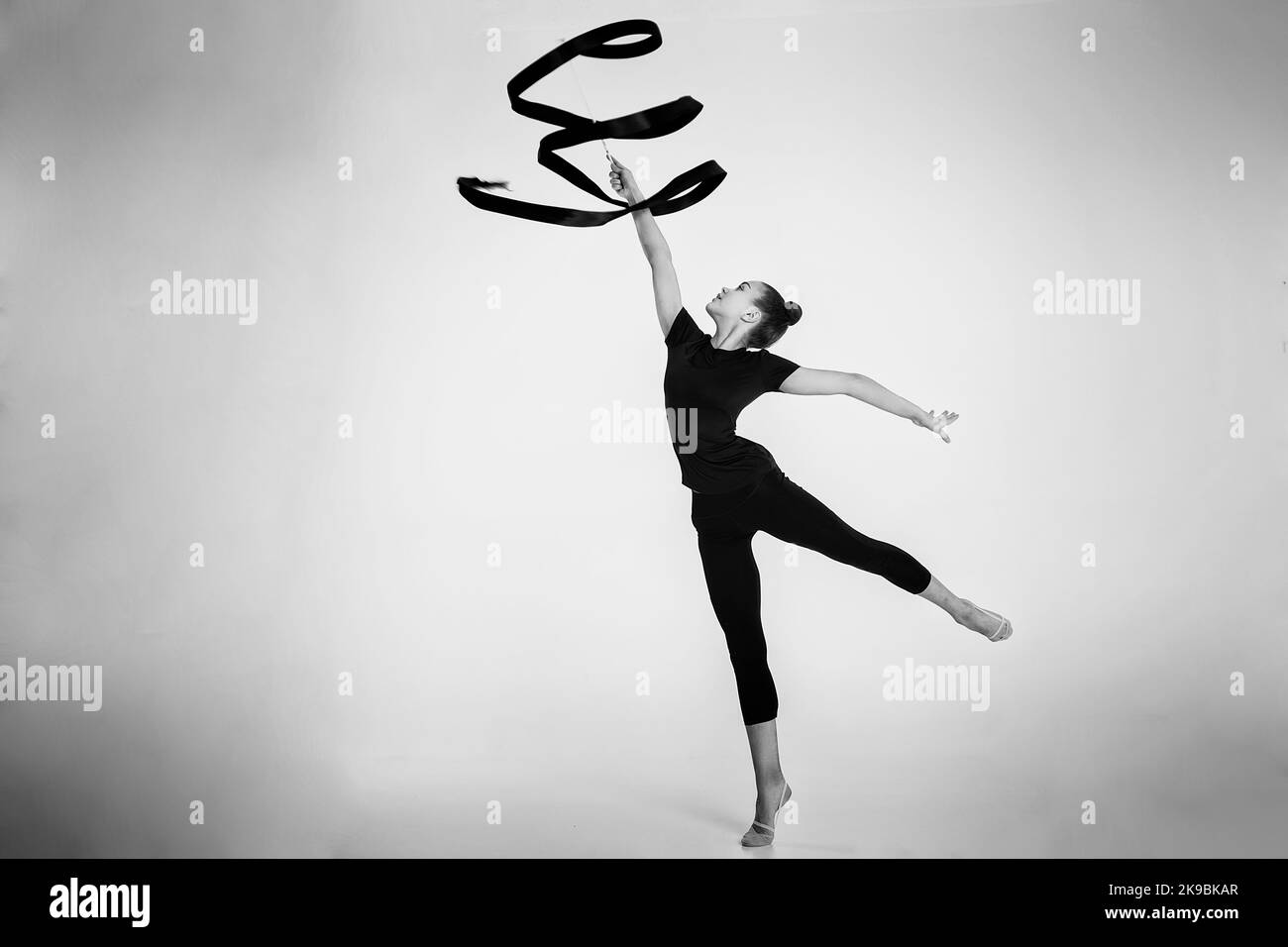 a girl from rhythmic gymnastics in a standing bodysuit shows an