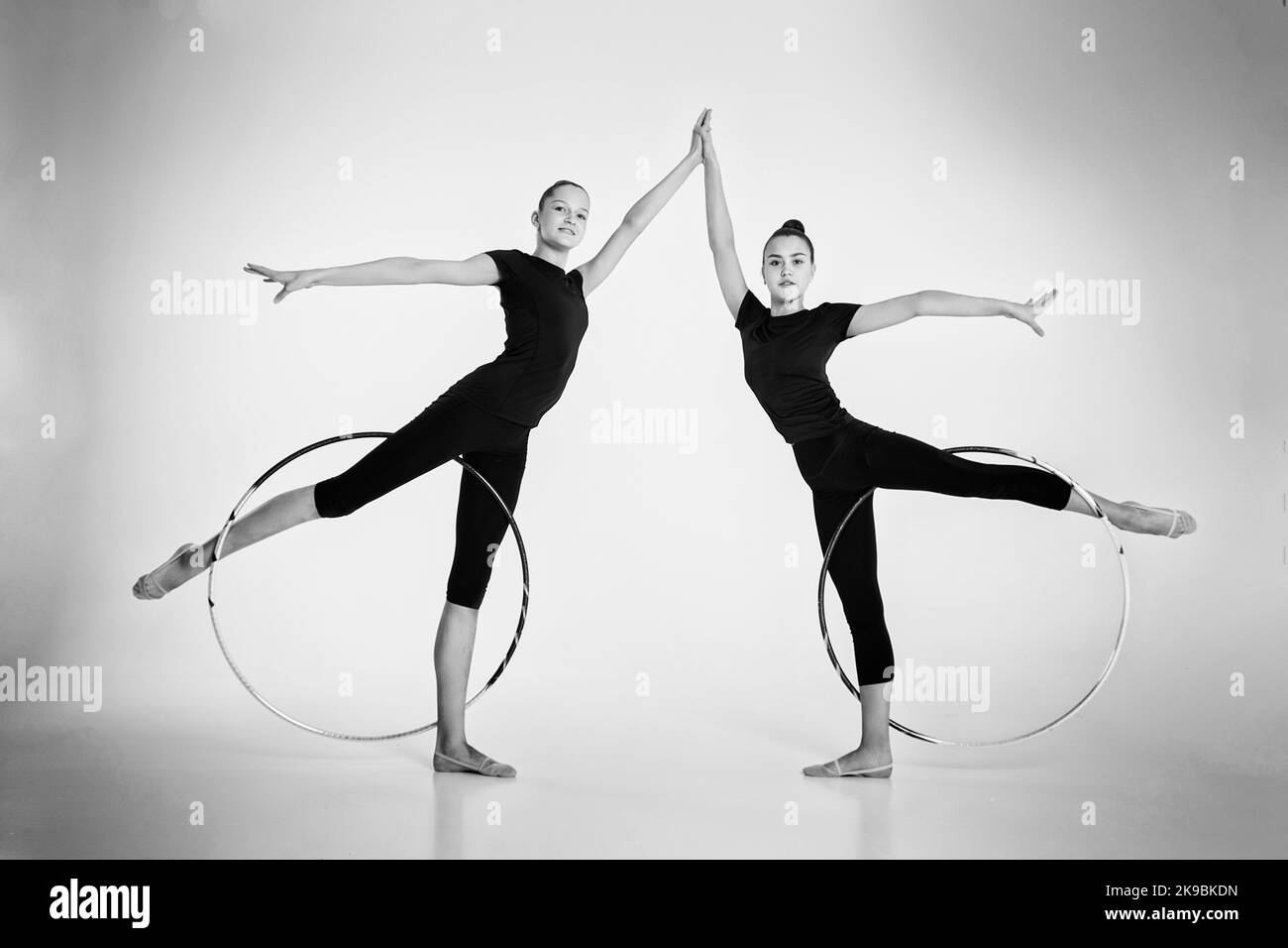 a two girls from rhythmic gymnastics in a bodysuit show a deflection