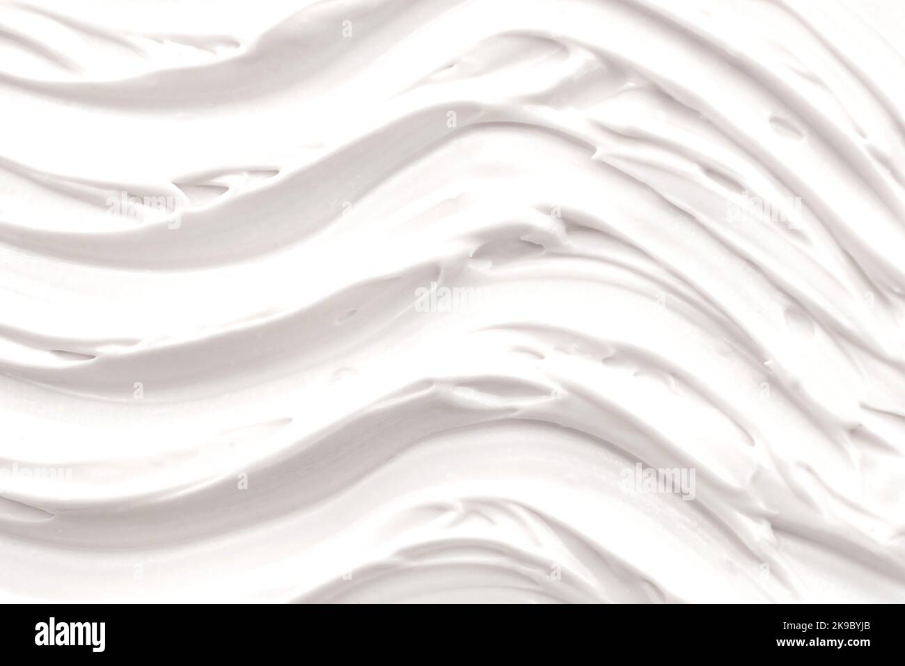 White foam texture close up background. Soapy substance with bubbles backdrop. Creamy grainy macro. Shower gel, washing liquid smears wallpaper. Cosme Stock Photo