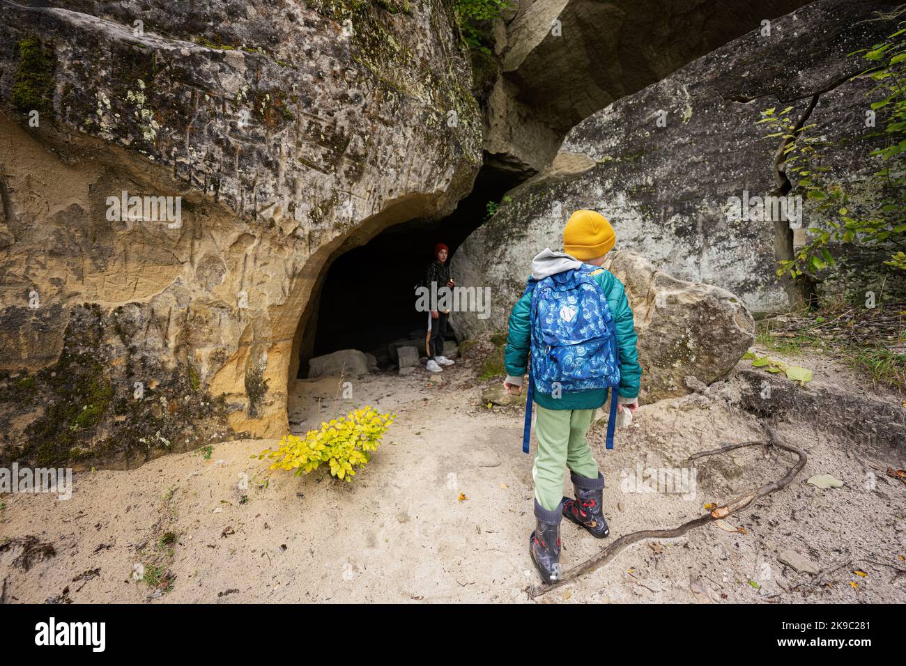 Two brothers wear backpack explore limestone stone caves at mountain in