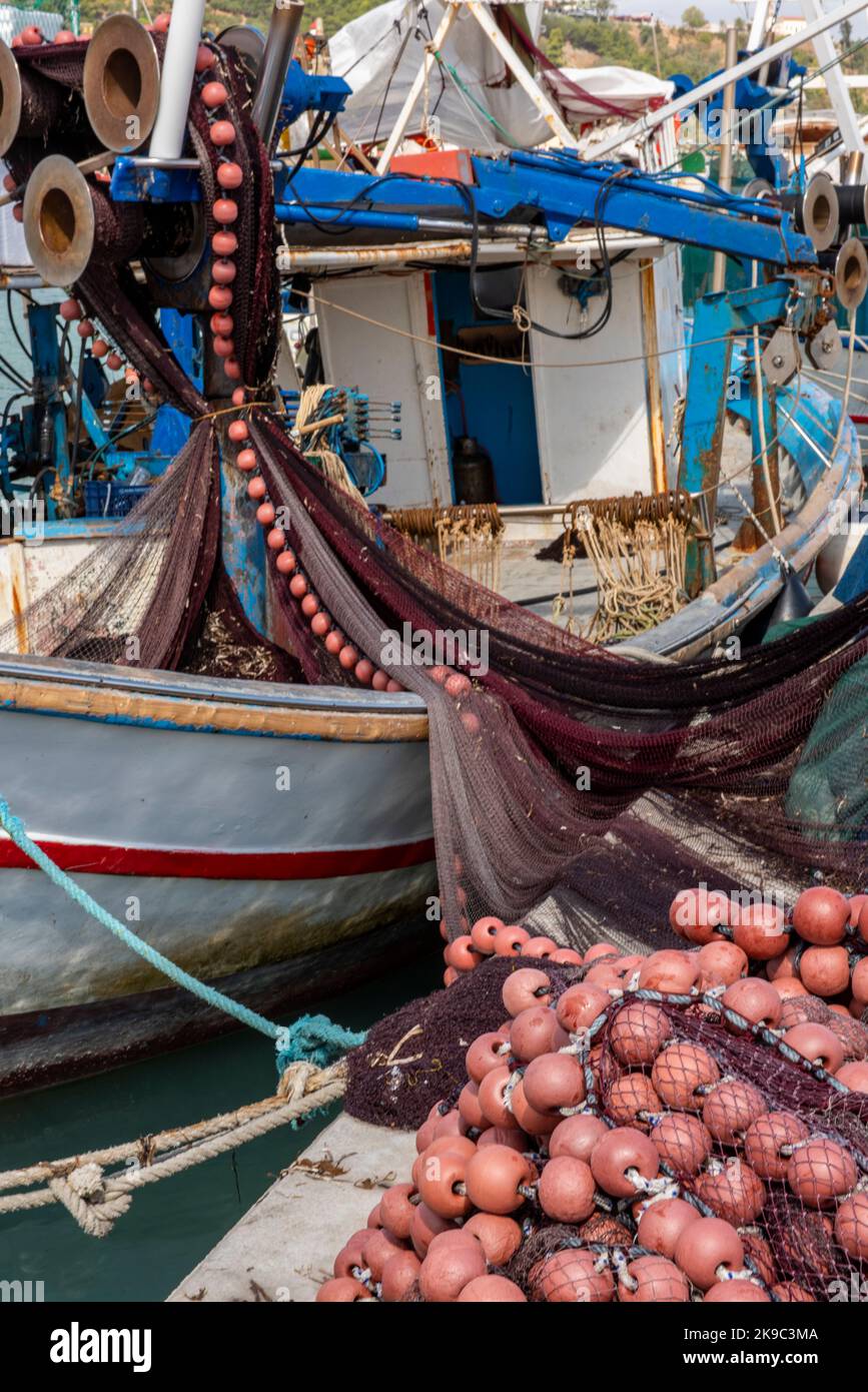 old greek fishing boats in the harbour at zante town in zakynthos, fishermens boats in port with nets hanging to dry and be repaired. Stock Photo