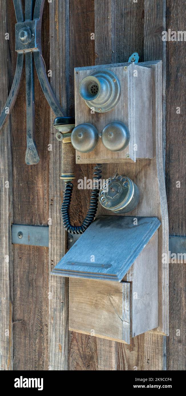 a vintage french telephone set with separate horn and speaker adorns a wooden wall Stock Photo