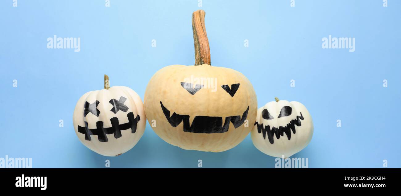 Halloween pumpkins with drawn faces on light blue background Stock ...