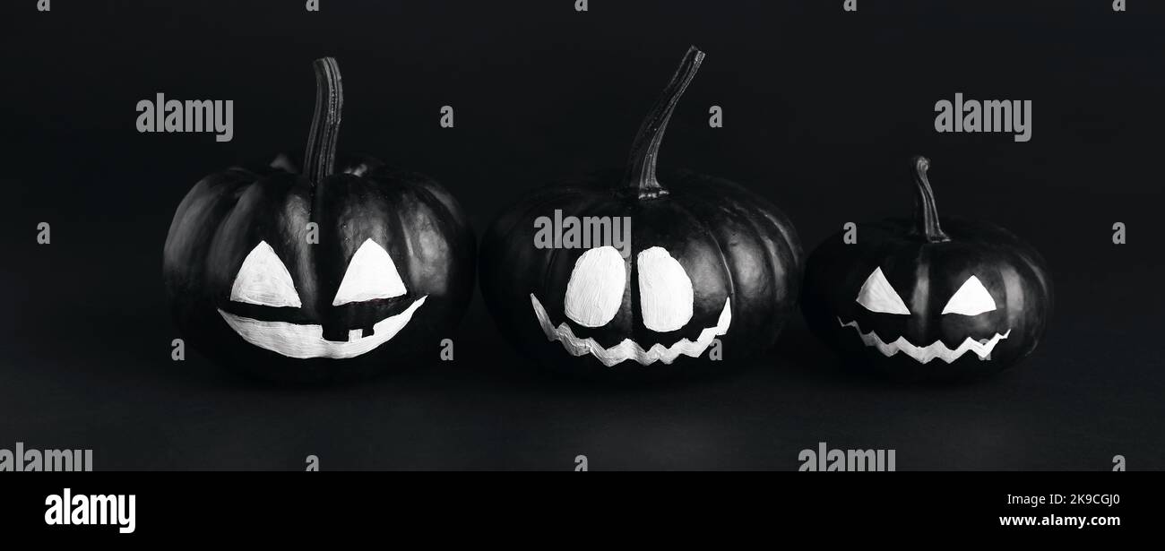 Halloween pumpkins with drawn faces on dark background Stock Photo - Alamy