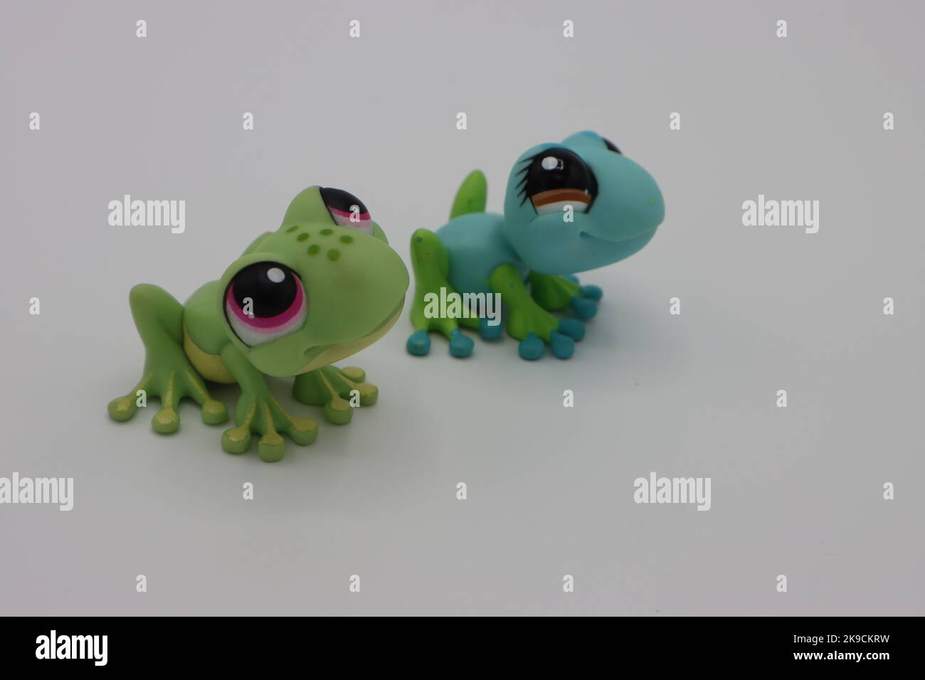 Tiny Cute Plastic Frog Animal Figures On A White Background tiny-cute-plastic-frog-animal-figures-on-a-white-background