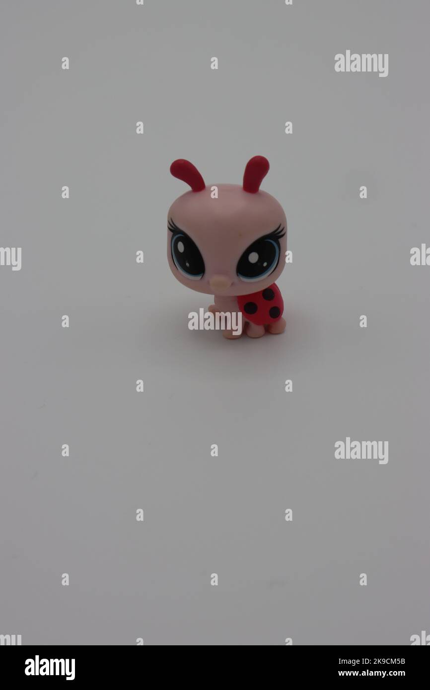 Tiny, cute plastic ladybird animal figure on a white background
