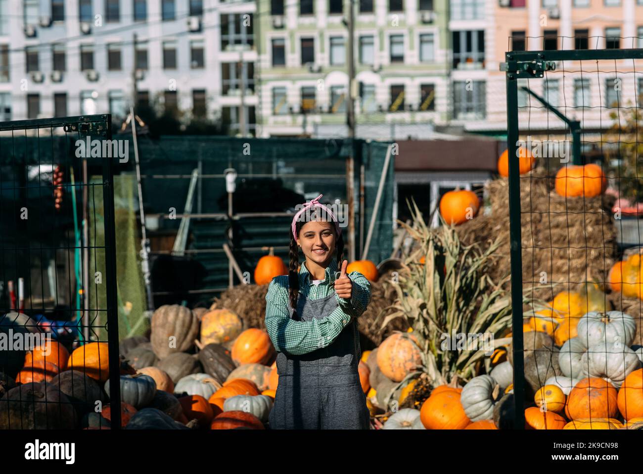 Farmer woman sells autumn pumpkin harvest at the market Stock Photo