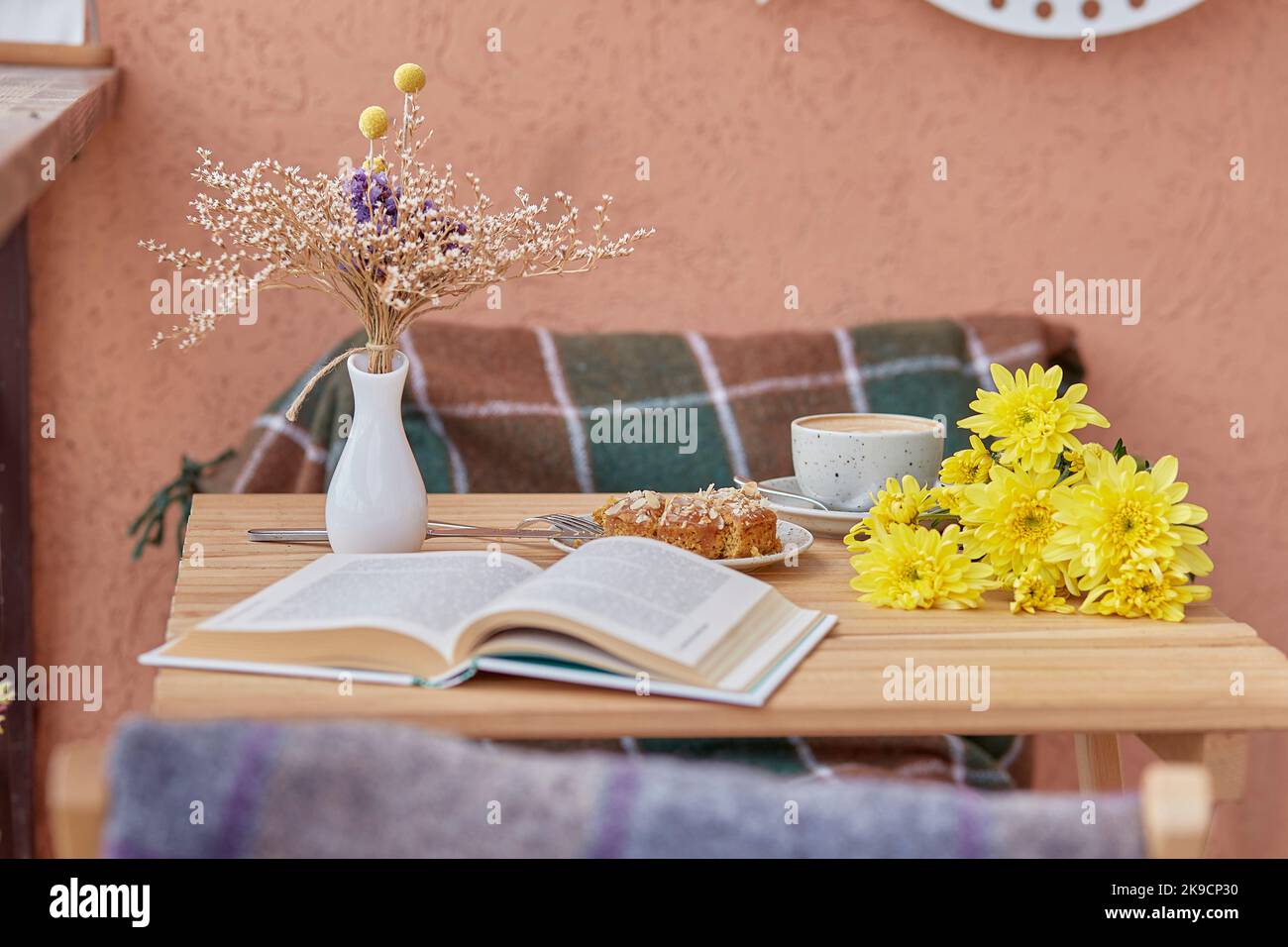 Aesthetic breakfast coffee, dessert and book. Cutting doughnut with