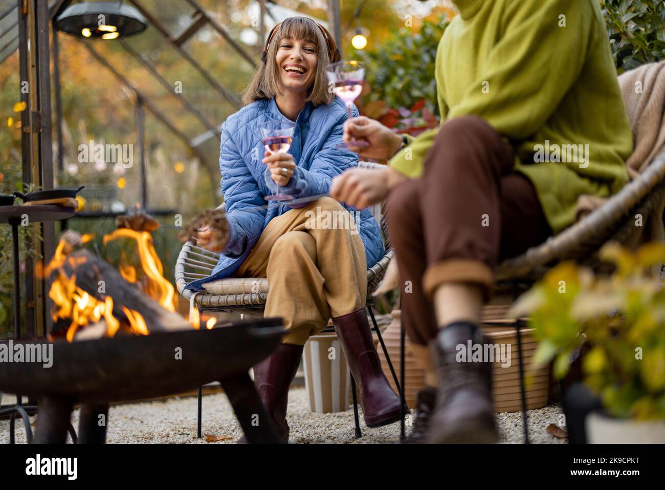 Young couple spending dinner time by the fire at backyard Stock Photo