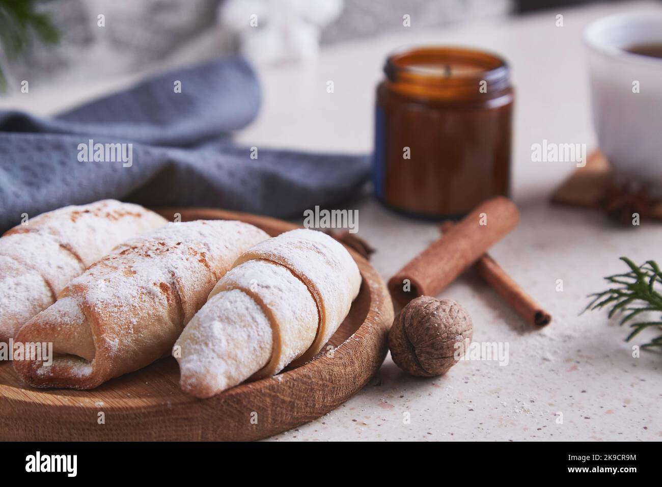 Classic aesthetic Christmas crescent handmade bagels with cinnamon sticks and walnuts. Cozy home. Stock Photo
