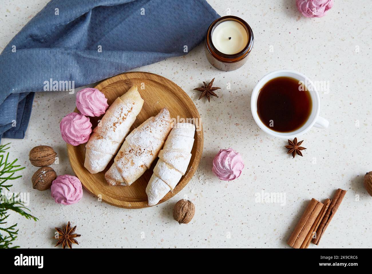 Cozy aesthetic handmade Christmas crescent bagels with cinnamon sticks, marshmallow, walnuts and coffee. Cozy home. Stock Photo