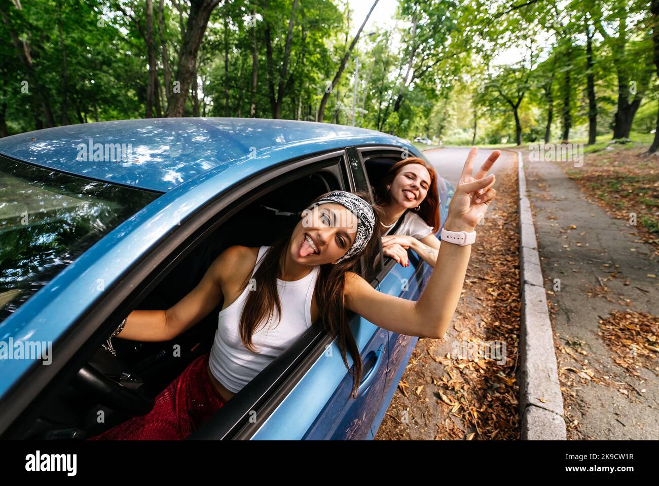 Two girlfriends fool around and laughing together in a car Stock Photo ...