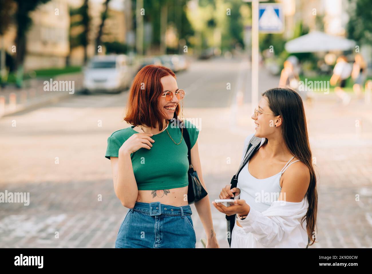Happy women talking and laughing at the city street Stock Photo - Alamy