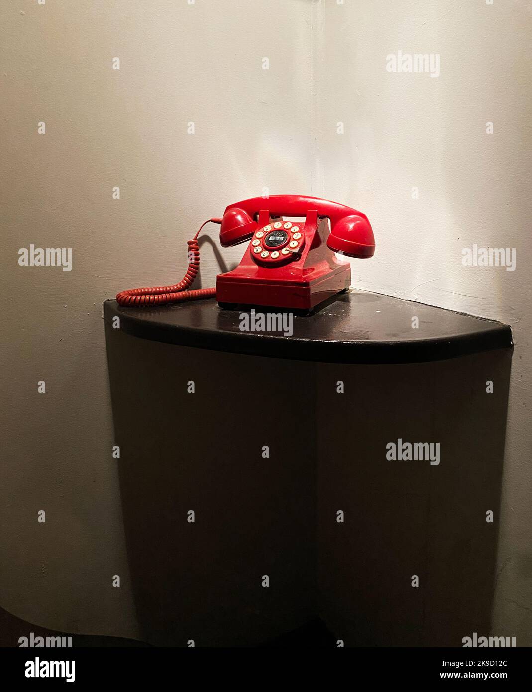 A red phone on a table. Emergency telephone. Stock Photo