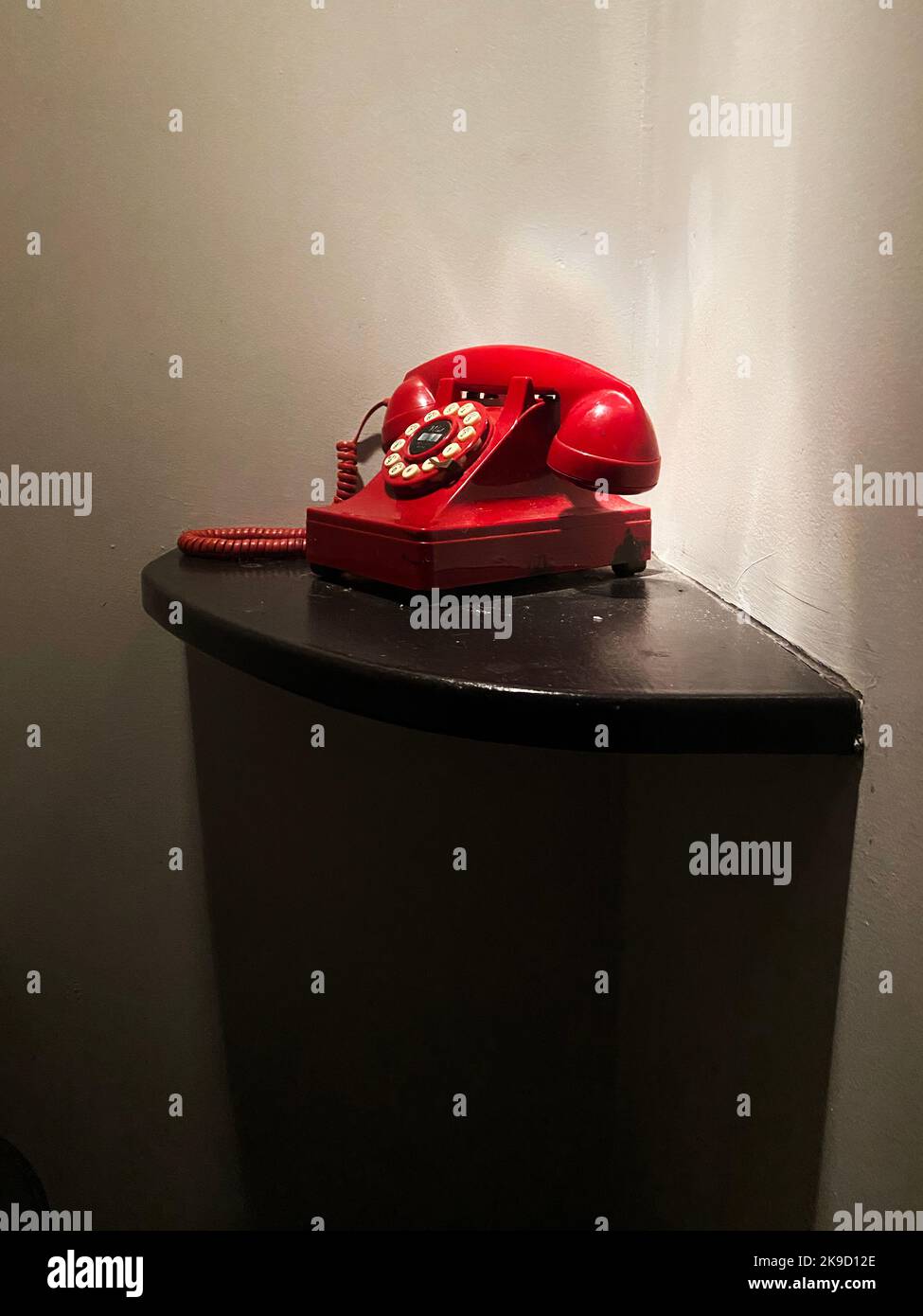 A red phone on a table. Emergency telephone. Stock Photo