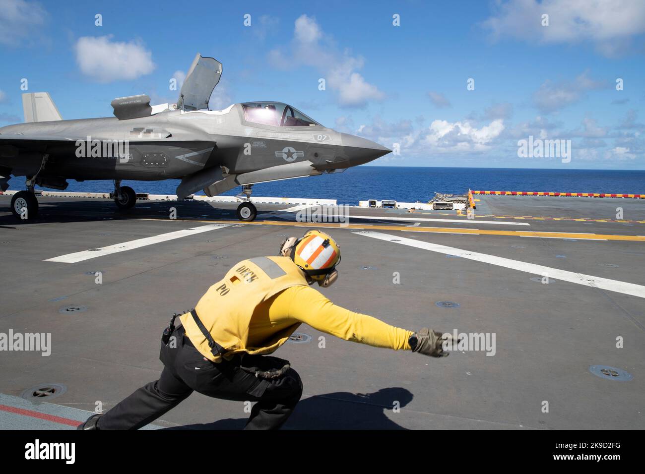 Aviation Boatswain’s Mate (Handling) 2nd Class Estin Worfe, from San Antonio, signals for an F-35B Lightning II aircraft assigned to Marine Medium Tiltrotor Squadron (VMM) 262 (Reinforced) to launch from amphibious assault ship USS Tripoli (LHA 7), Aug. 16, 2022. Stock Photo
