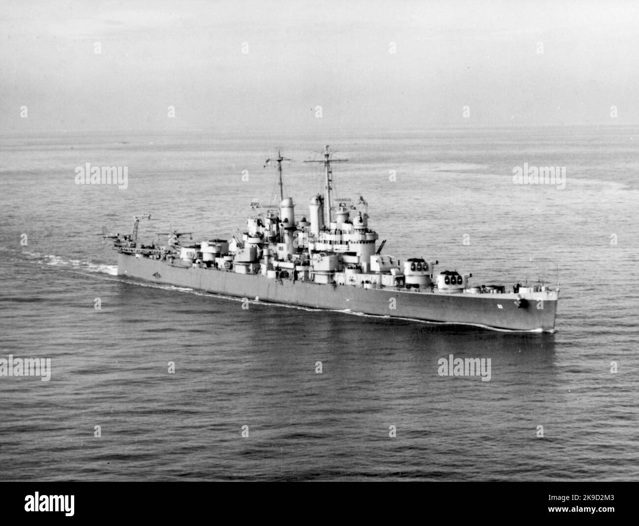 The U.S. Navy light cruiser USS Cleveland (CL-55) underway at sea in late 1942. Note that the ship's forward 152 mm gun turrets and gun director appear to be tracking the photo aircraft. USS Cleveland (CL-55) was the lead ship and one of the 27 United States Navy Cleveland-class light cruisers completed during or shortly after World War II. She was the second ship to be named for the city of Cleveland, Ohio. Stock Photo