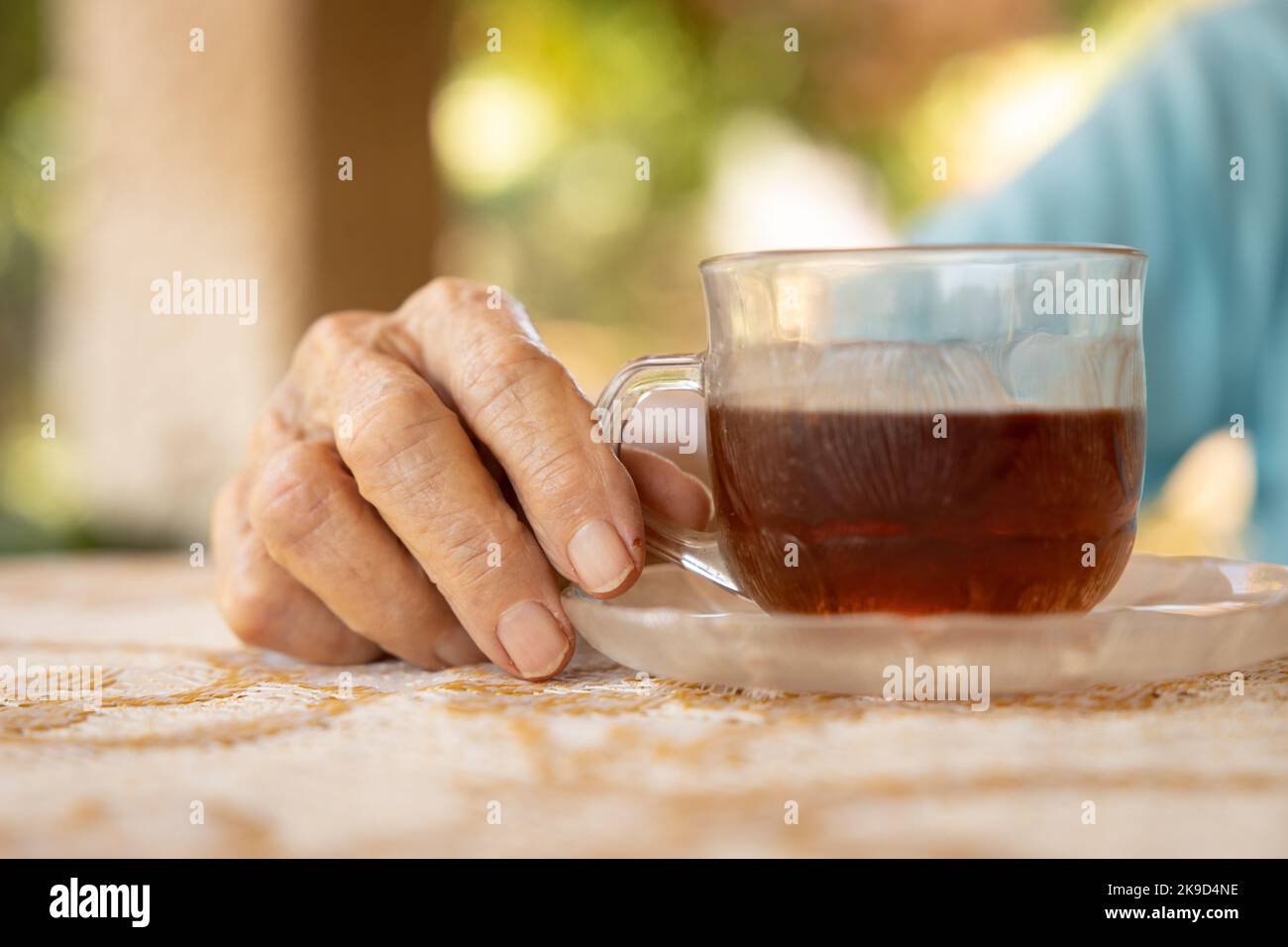 hands of an elderly woman holding a cup of tea Stock Photo