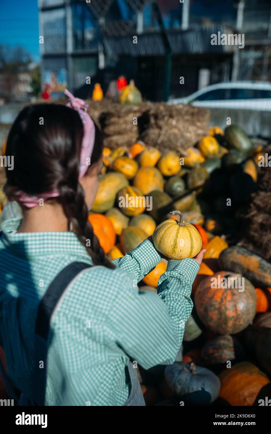Woman with a small pumpkin among the autumn harvest Stock Photo