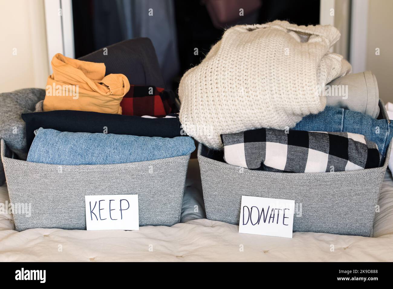 Two baskets with closes to keep and donate. Closet sorting and ...