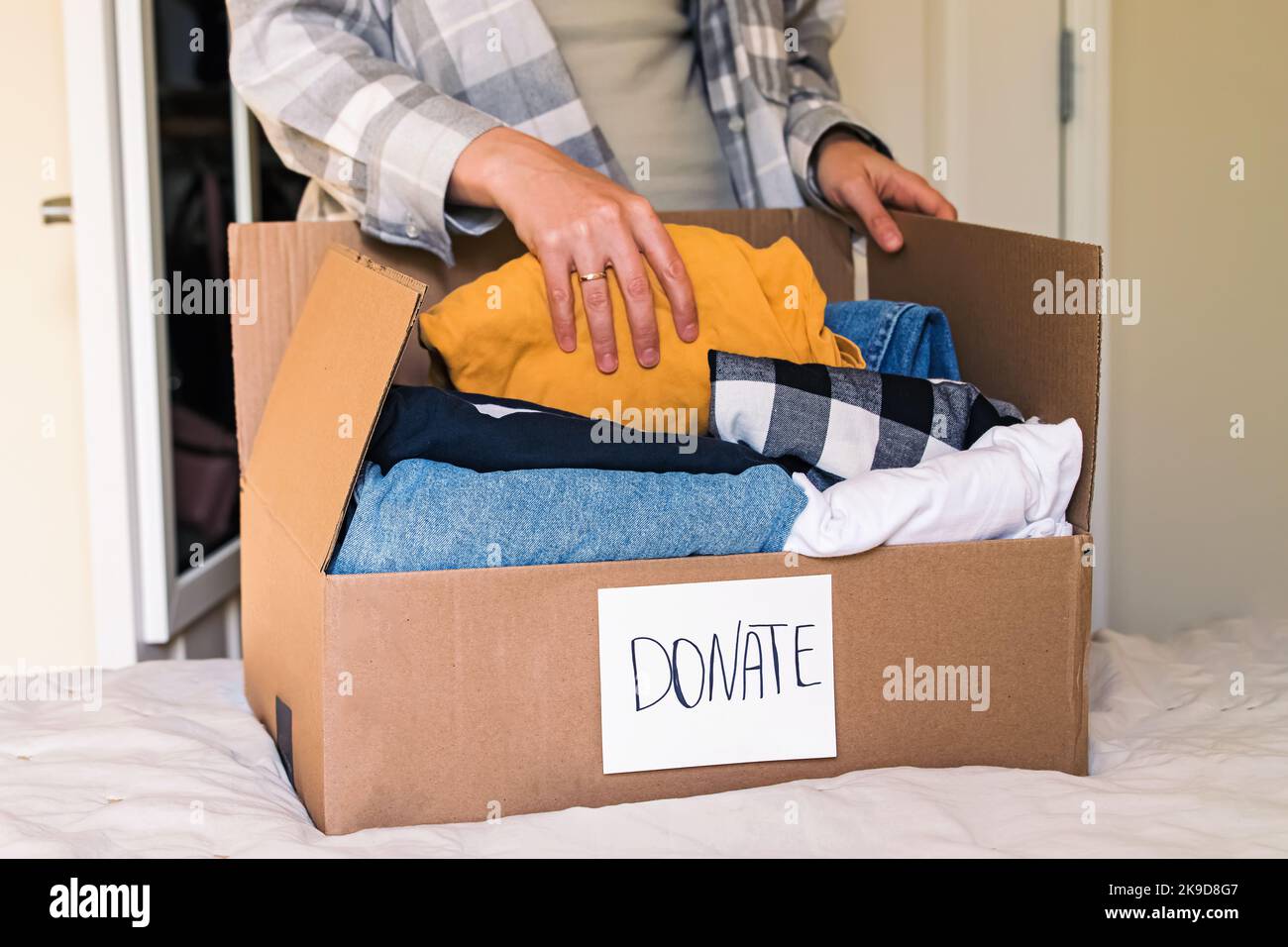 Woman sorting her clothes to donate. Sustainable lifestyle, charity