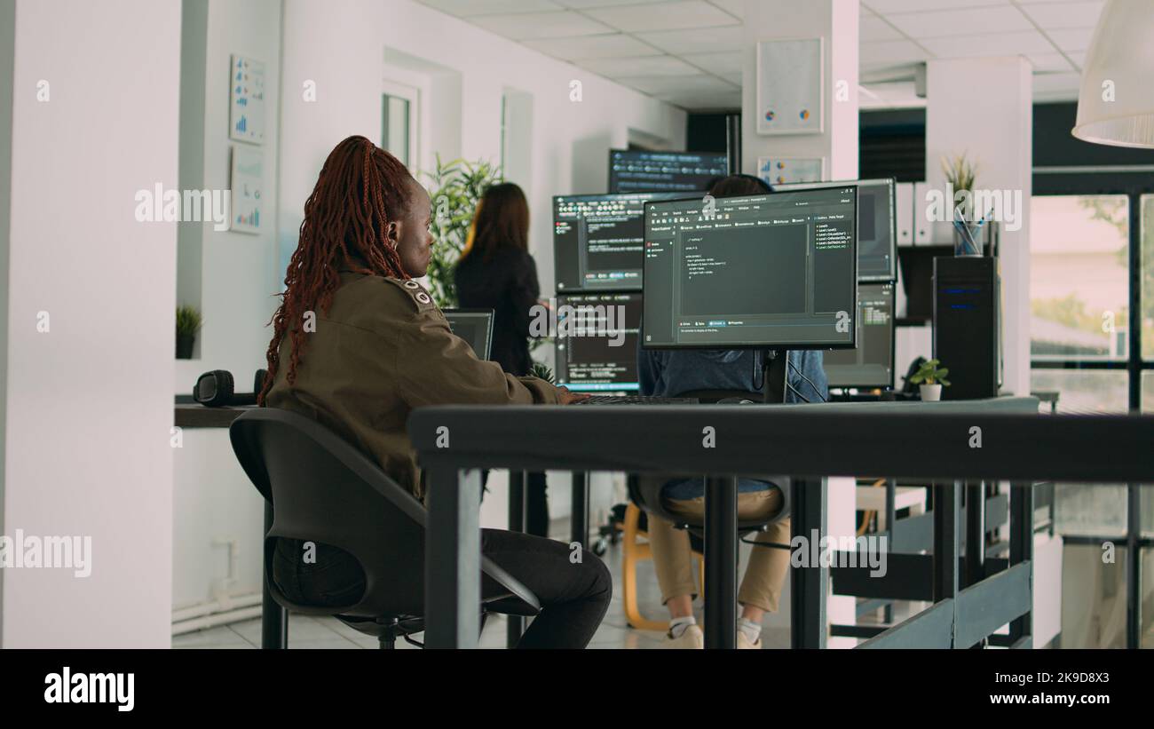 African american programer typing source code on computer to create new user interface. Software engineer writing data in html language to develop security server on terminal window. Stock Photo