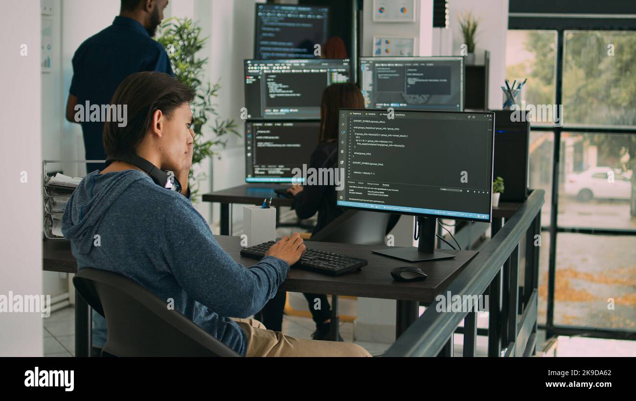 Asian software engineer working on security program with server code, typing system information on computer screen. Database programer writing code with algorithms, it language. Stock Photo