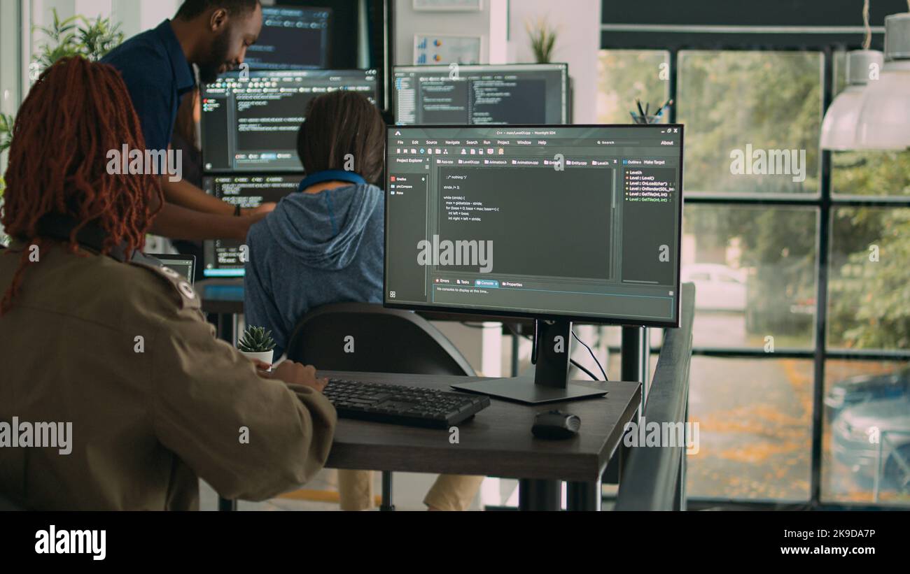 App software developer typing machine learning app code on computer, sitting at desk in big data company office. Cloud programer working on new program interface in cyber security agency. Stock Photo