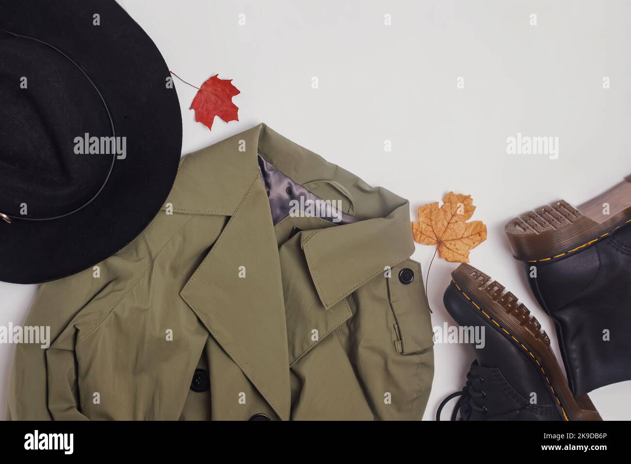 Autumn outfit essentials. Trench coat, boots and hat on the white ...