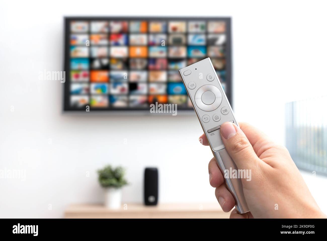 Multimedia video streaming concept. Television set, remote control in hand Stock Photo