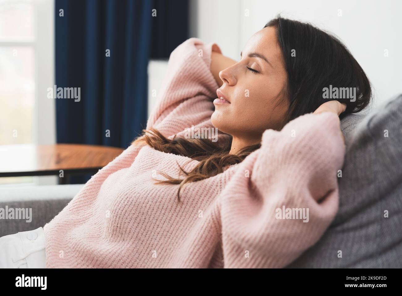 Woman relaxing at home. Young brunette woman thinking at home in a leisure time Stock Photo