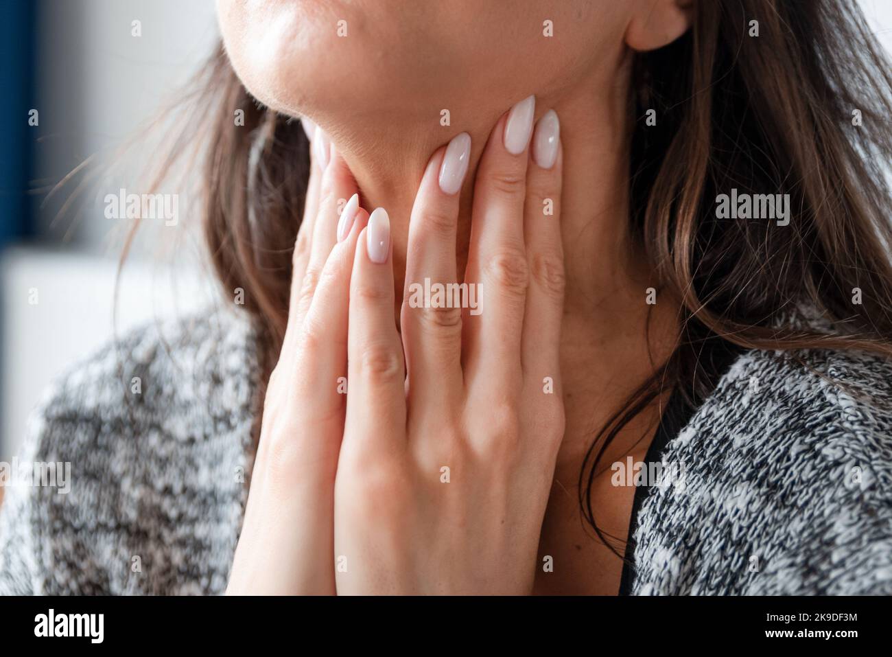 Young woman self examination thyroid gland. Hashimoto or thyroid cancer concept Stock Photo