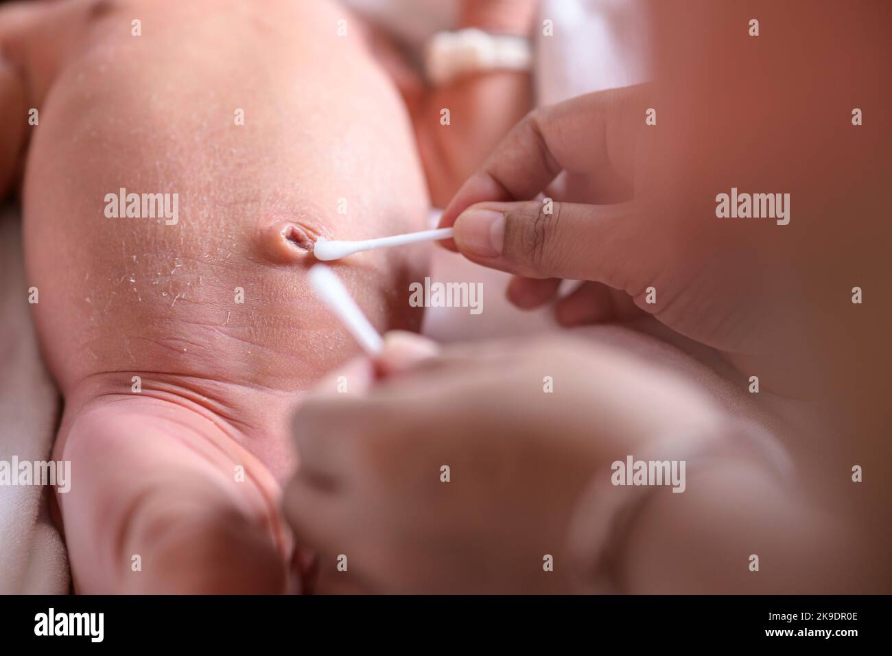 Mother cleaning the navel of newborn baby closeup Stock Photo