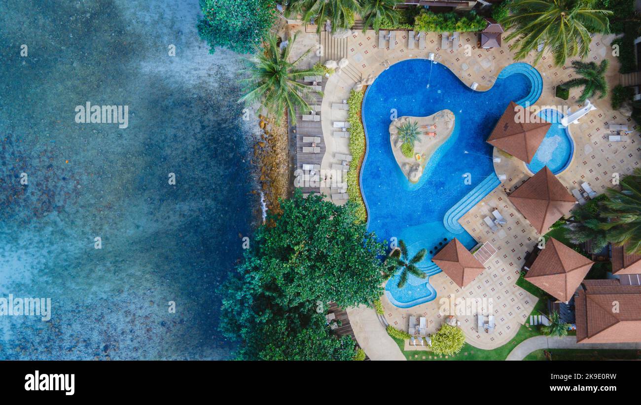 Drone aerial view of a luxury hotel pool from above. A couple of men ...