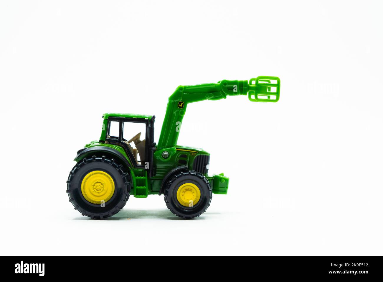 Green tractor toy with yellow wheels on white Stock Photo Alamy