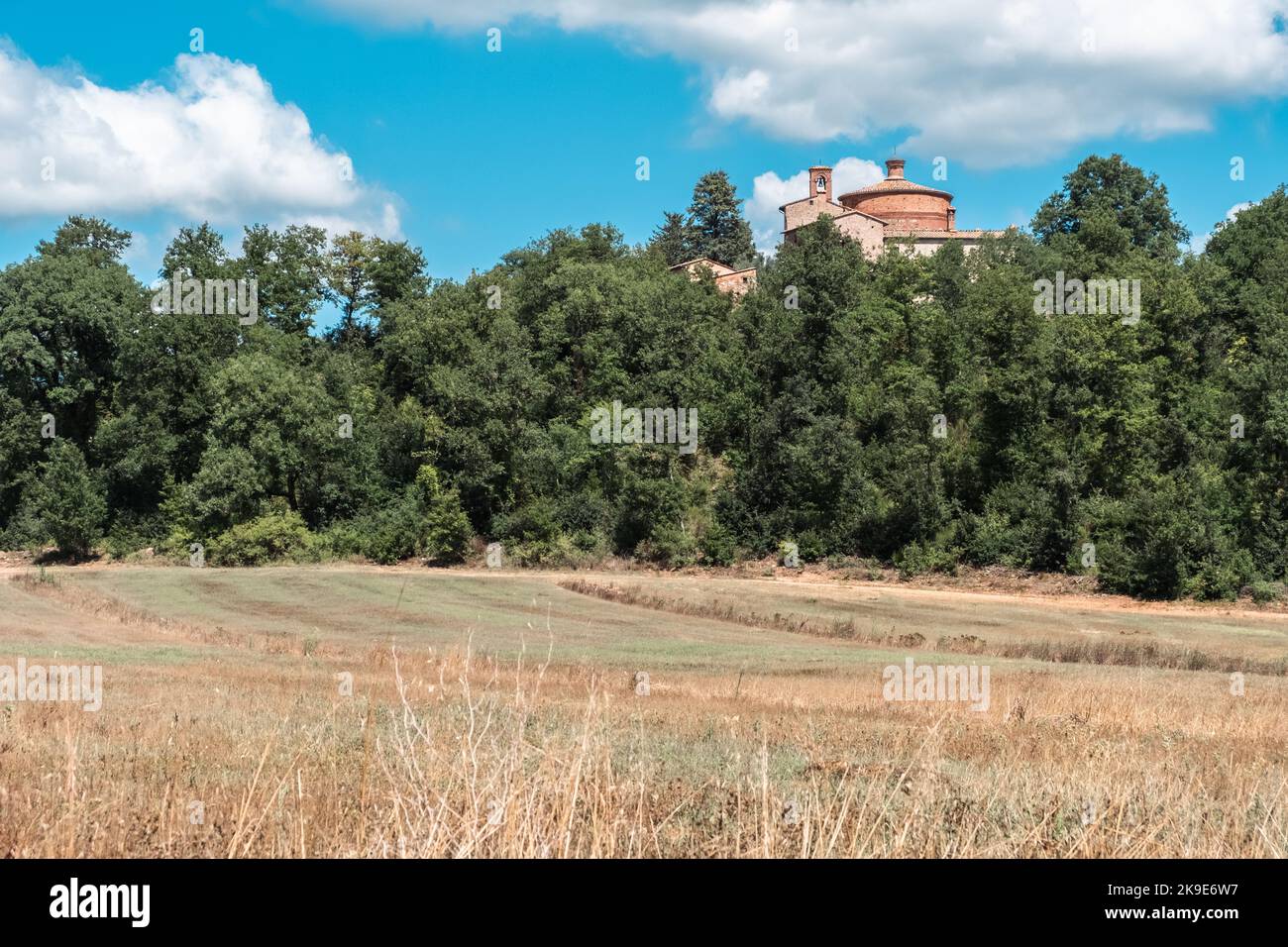Green fields of Tuscany with a large ancient country house at the ...