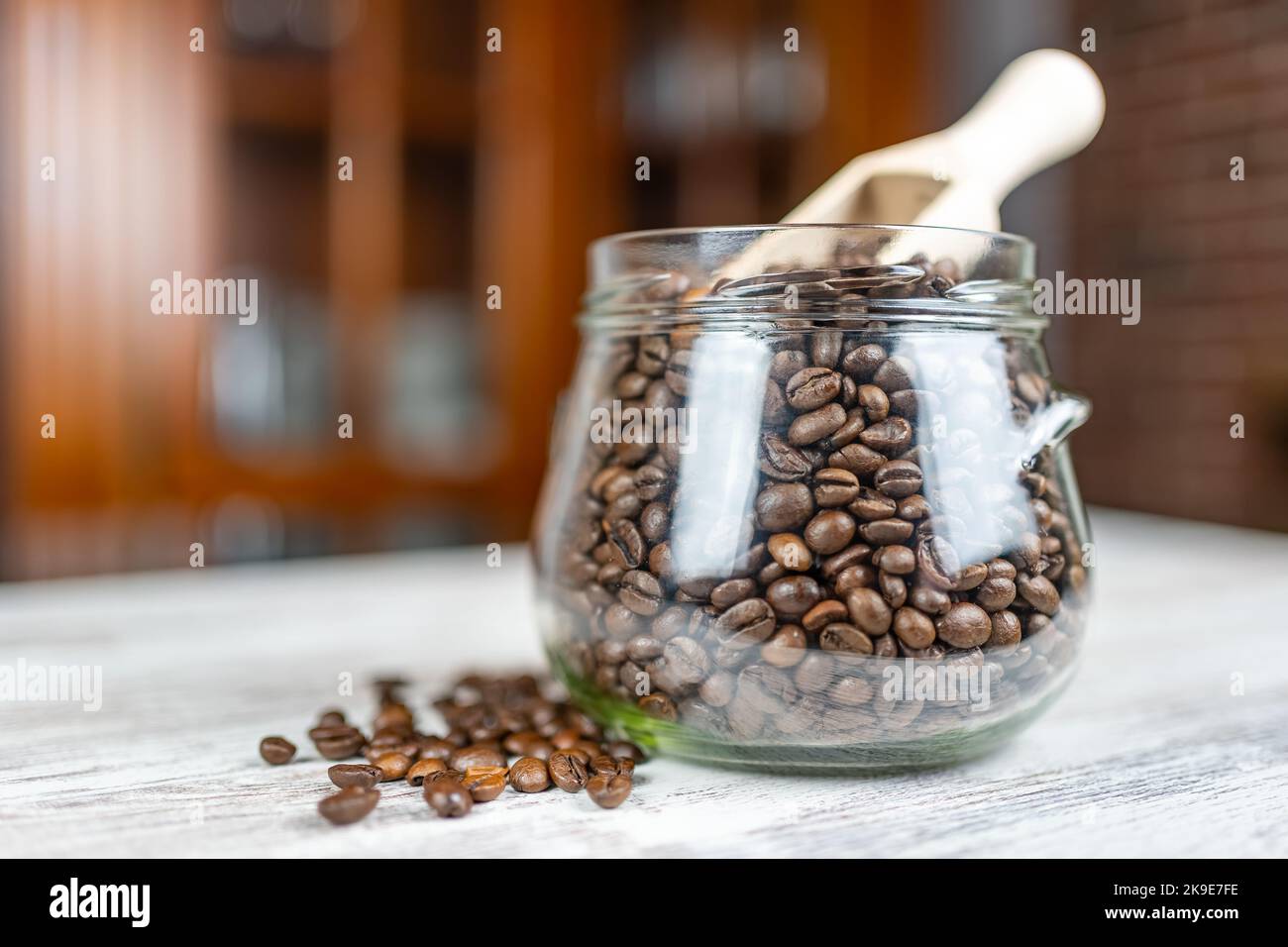 Coffee beans roasted naturally in an antique glass jar and wooden spoon