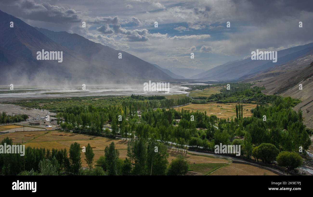 Panorama view of Wakhan Corridor in Tajikistan Pamir mountains with Hindu Kush range in Afghanistan and sandstorm on Panj river Stock Photo