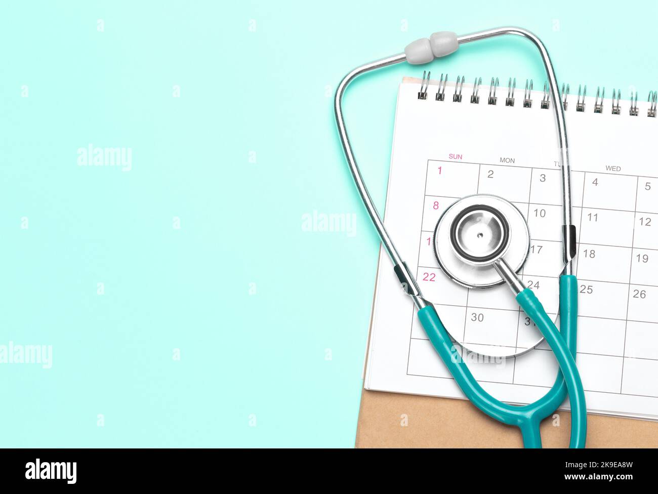 Green stethoscope and calendar on a green background. Template Copy space for text. mock-up. Stock Photo