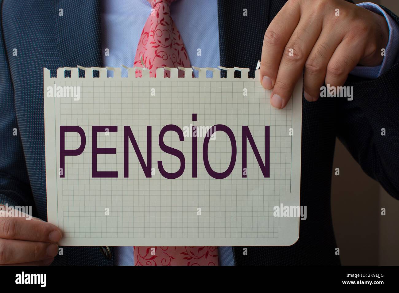The paper in the hand of the man in the suit reads ''pension''. Stock Photo