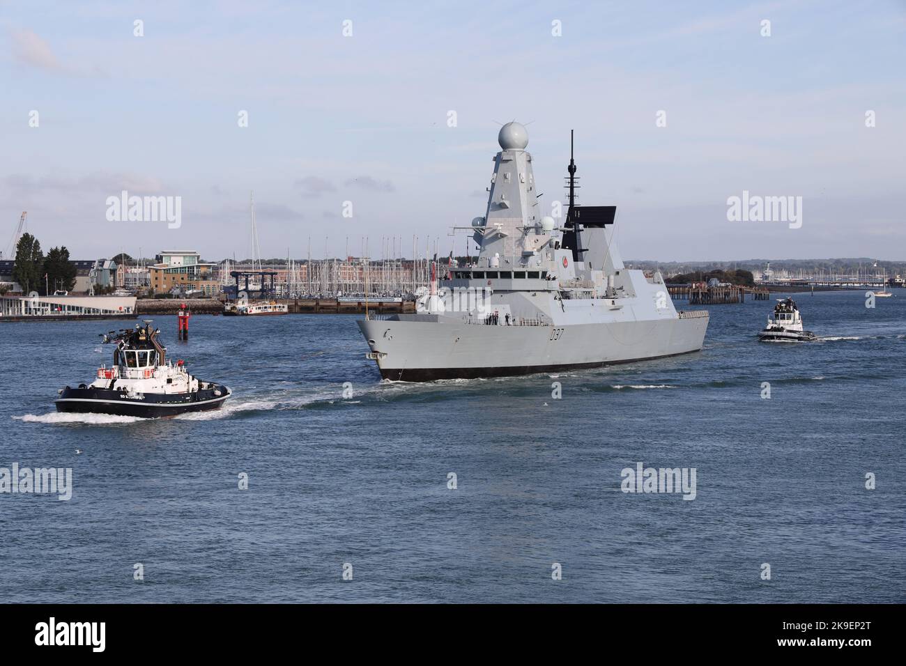 Tugs escort the Royal Navy Type 45 destroyer HMS DUNCAN out of the harbour Stock Photo