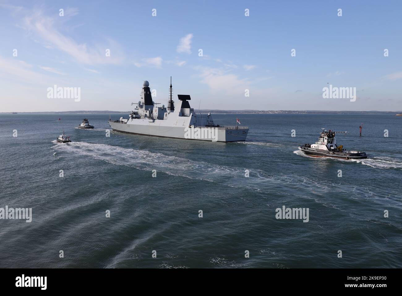 Tugs and the Admiralty pilot launch escort the Royal Navy Type 45 destroyer HMS DUNCAN into The Solent Stock Photo
