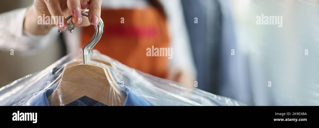 Worker giving to client clean clothes hanging on hangers at dry cleaning company Stock Photo Alamy