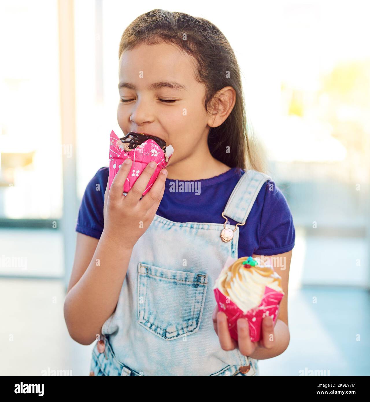 You can see the delight in her face. an adorable little girl eating a