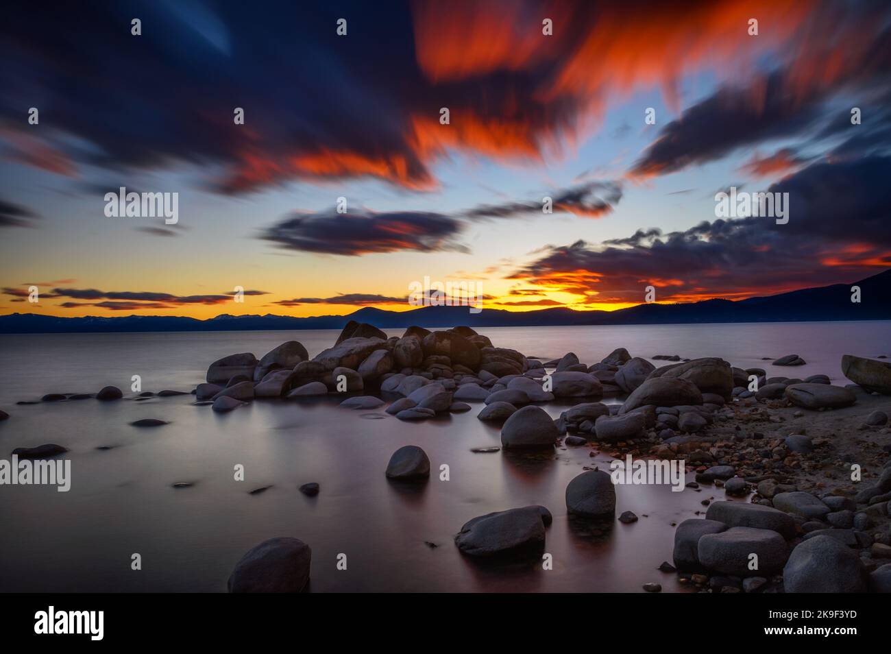 Sunset above rocky beach of Lake Tahoe in California Stock Photo