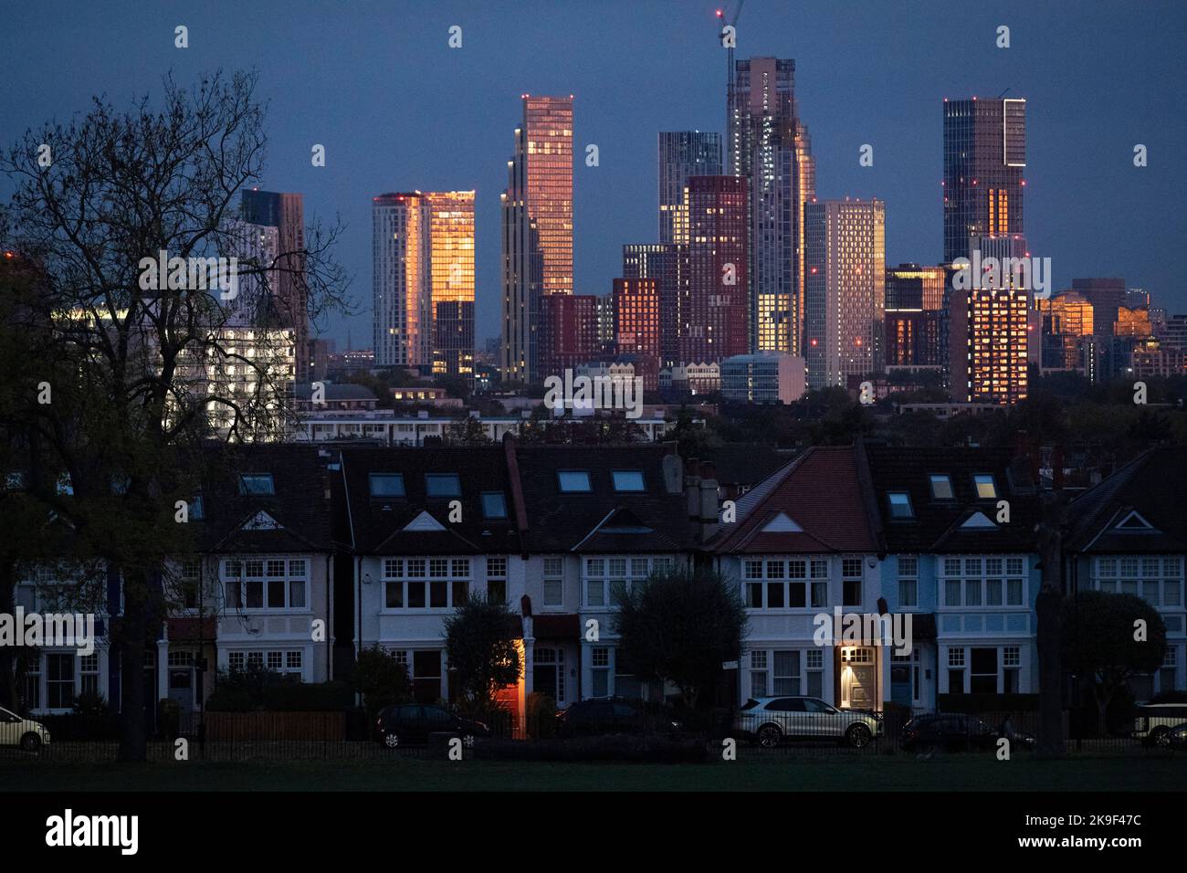 A lit porch of a terraced period house and in the distance, the growing development at Nine Elms at Battersea, seen from Ruskin Park, a south London green space in Lambeth, on 27th October 2022, in London, England. Stock Photo