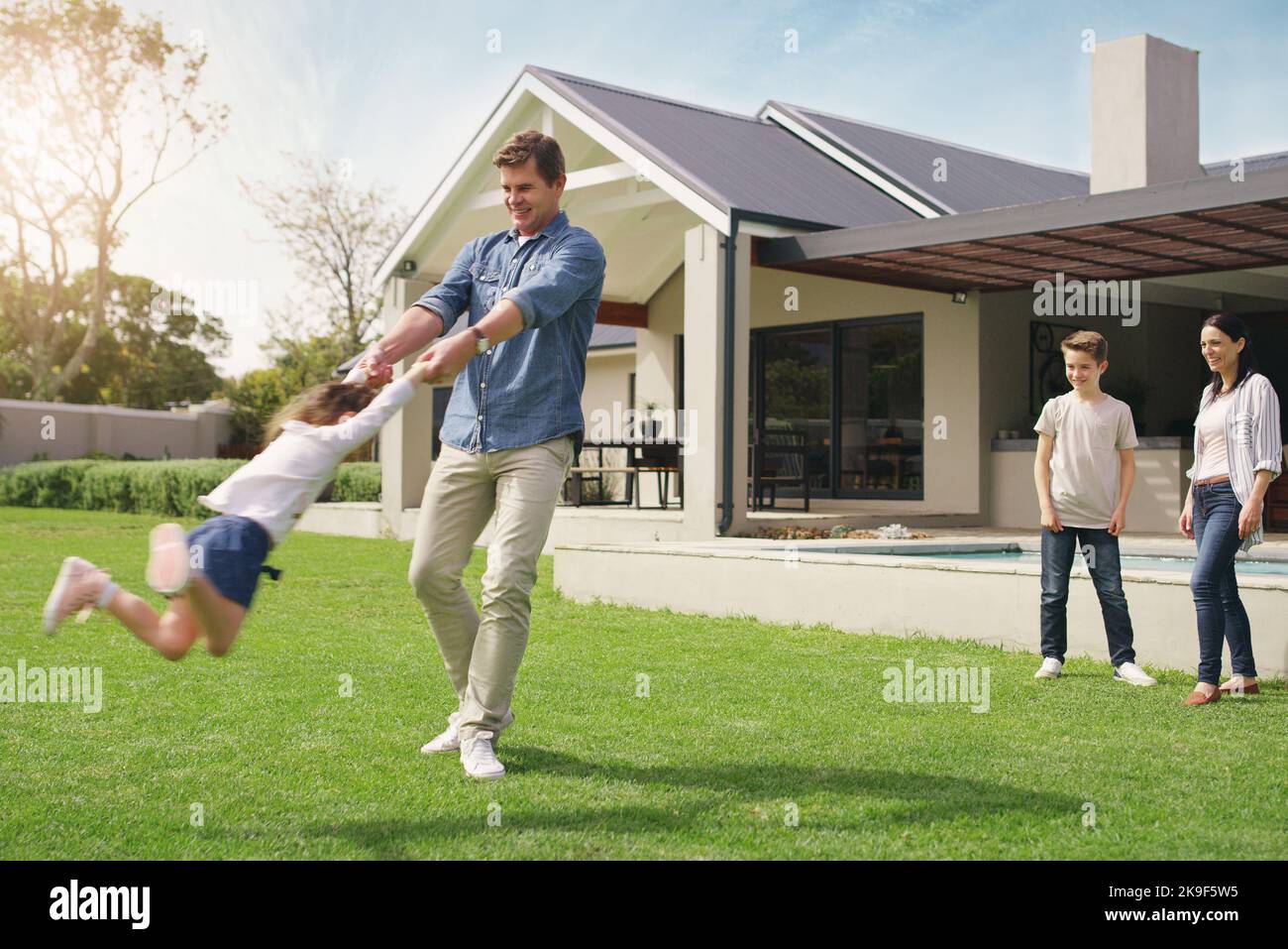 Domestic bliss at its best. a happy young family playing together in their front yard. Stock Photo