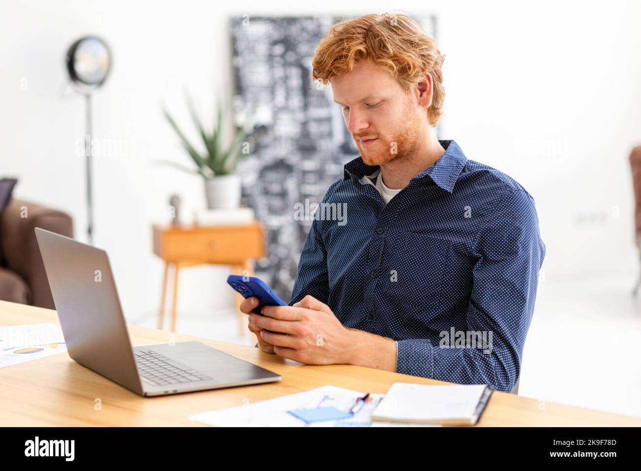 Concentrated man entrepreneur using smartphone, working, writes message using mobile phone discussing something Stock Photo